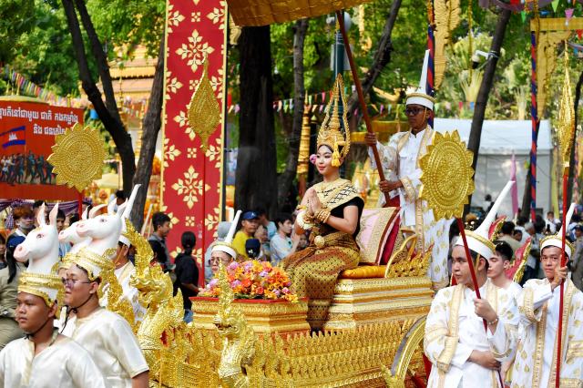 A woman representative of the New Year angel, sits on a Royal ox-cart as people parade during celebrations for the Khmer New Year, known as Nokor Sankranta, in Phnom Penh on April 16, 2026. (Photo by TANG CHHIN Sothy / AFP)