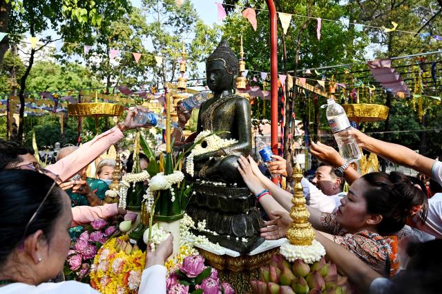 People pour water on a Buddha statue during celebrations for the Khmer New Year, known as Nokor Sankranta, in Phnom Penh on April 16, 2026. (Photo by TANG CHHIN Sothy / AFP)