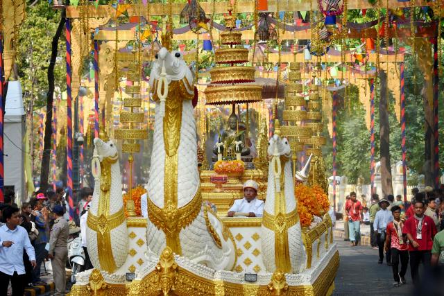 A Royal float transport a Buddha statue as people parade during celebrations for the Khmer New Year, known as Nokor Sankranta, in Phnom Penh on April 16, 2026. (Photo by TANG CHHIN Sothy / AFP)