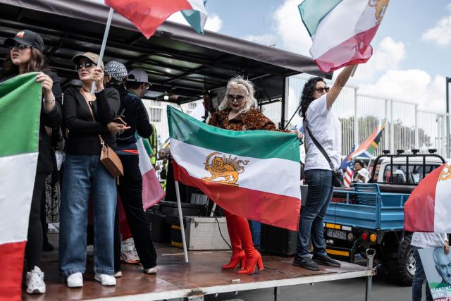 Iranian pro-democracy activists wave the pre-1979 Iranian national flag during a protest in front of the US Consulate in Sandton, on April 16, 2026. (Photo by ILARIA FINIZIO / AFP)