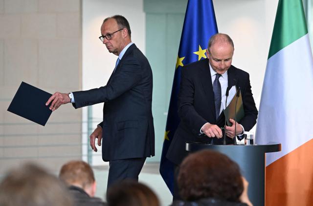 German Chancellor Friedrich Merz (L) and Ireland's Prime Minister Micheal Martin leave after a press conference at the Chancellery in Berlin on April 16, 2026, after bilateral talks. (Photo by RALF HIRSCHBERGER / AFP)