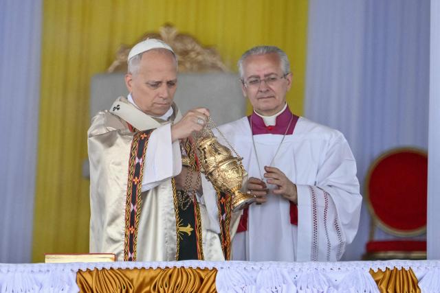 Pope Leo XIV (L) holds the thurible as he leads the Holy Mass at Bamenda Airport in Bamenda, on the fourth day of an 11-day apostolic journey to Africa, on April 16, 2026. (Photo by Alberto PIZZOLI / AFP)