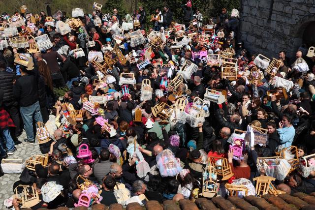 Pilgrims, including childless couples, with toy cradles participate in the Tsachkhuroba pilgrimage to the hill-sit Archangel monastery to pray God and ask for mercy and for a child, in the village of Tsachkhuri on April 16, 2026. Thousands joined the 3 km uphill monastery procession in an annual fertility pilgrimage, happening on Thursday of the week following Orthodox Easter. (Photo by Giorgi ARJEVANIDZE / AFP)