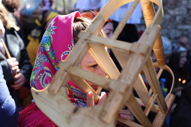 Pilgrims, including childless couples, with toy cradles participate in the Tsachkhuroba pilgrimage to the hill-sit Archangel monastery to pray God and ask for mercy and for a child, in the village of Tsachkhuri on April 16, 2026. Thousands joined the 3 km uphill monastery procession in an annual fertility pilgrimage, happening on Thursday of the week following Orthodox Easter. (Photo by Giorgi ARJEVANIDZE / AFP)
