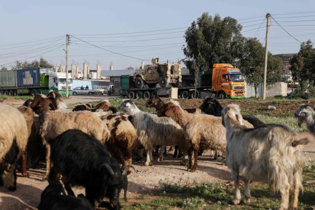 A herd of goats and sheep stand in a field as a convoy of US military equipment is transported along the DamascusAmman highway toward the southwestern city of Daraa, following the completion of the US withdrawal from their bases, as it travels near the capital Damascus on April 16, 2026. Syria said on April 16, it had taken control of all military bases hosting US troops who were deployed in the country for years leading an international coalition against the Islamic State (IS) group. In recent months, Syria's new Islamist government has expanded its control to parts of the country's northeast that were previously held by US-allied Kurdish forces, while the government has also formally joined the international anti-IS coalition. (Photo by Bakr ALkasem / AFP)