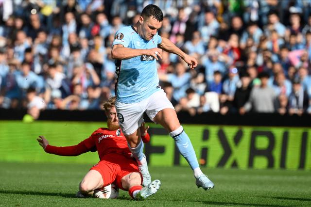 Celta Vigo's Spanish forward #09 Ferran Jutlga is tackled by Freiburg's German midfielder #19 Niklas Beste (L) during the UEFA Europa League quarter final second leg football match between RC Celta de Vigo and SC Freiburg at Balaidos Stadium in Vigo on April 16, 2026. (Photo by Miguel RIOPA / AFP)