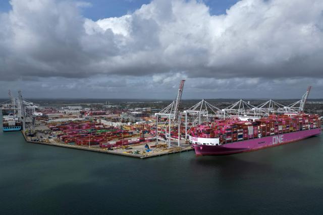 An aerial picture shows freight containers on the dock as ship to shore cranes load the One Inspiration cargo ship, registered under the flag of Liberia, at the container terminal of Southampton Docks in Southampton on the south coast of England on April 16, 2026. Britain's economy grew much stronger than expected in February, prior to the start of the Middle East war, official data showed on April 16, ahead of a likely hit from the US-Iran conflict. UK gross domestic product growth climbed to 0.5 percent in February compared with expansion of 0.1 percent in January, the Office for National Statistics said in a statement. (Photo by Ben STANSALL / AFP)