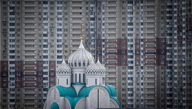 This photographs shows St. Nicholas Cathedral in front of a huge block apartment building on the Zhivopisaya Embankment in Krasnogorsk, outside Moscow, on April 16, 2026. (Photo by Alexander NEMENOV / AFP)