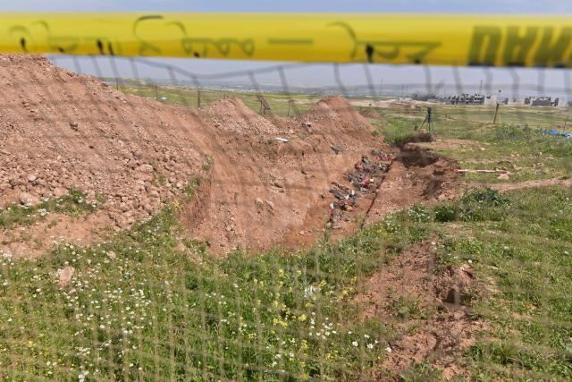 Forensic experts open a mass grave believed to contain the remains of dozens of people executed by the Islamic State (IS) group during its 2014 entry into the northern city of Mosul, when it captured the city from the Iraqi Army, in the Mushairifa area of Mosul on April 16, 2026.. Work began on April 16, to recover remains from a mass grave dating back to the period when the Islamic State was in control of the city of Mosul in northern Iraq, an official told Agence France-Presse. Ahmed al-Asadi, head of the teams excavating mass graves in Iraq, told AFP, “Today, our teams began the process of exhuming” remains from a mass grave located in the al-Haramat area west of Mosul in Nineveh province. (Photo by Zaid AL-OBEIDI / AFP)
