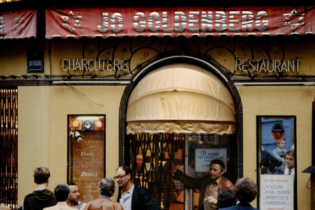 (FILES) People stand on August 11, 1982 in front of the Jo-Goldenberg restaurant rue des Rosiers in Paris, two days after it was devastated by an attack by gunmen that threw a grenade into the restaurant and shot at customers with sub-machine guns, killing six customers and injuring 22 others. The Palestinian Authority extradited suspect Hicham Harb to France on April 16, 2026 who is wanted over an attack against a Jewish restaurant in Paris in 1982, his lawyer told AFP. Harb is one of four suspects sought in connection with the attack on the Jo Goldenberg restaurant in the Marais, a Jewish neighbourhood in Paris on August 9, 1982. (Photo by JOEL ROBINE / AFP)