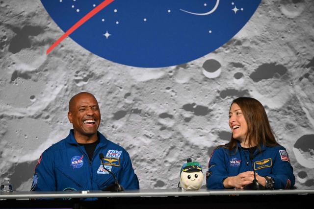 NASA's Artemis II mission astronauts Victor Glover (L) and Christina Koch share a light moment during a press conference at Johnson Space Center in Houston, Texas, on April 16, 2026. The astronauts did the first slingshot around the Moon in more than 50 years and traveled deeper into space than any humans before, culminating in a smooth splashdown on April 10 off the coast of California. (Photo by RONALDO SCHEMIDT / AFP)