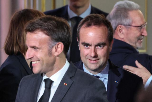 France's Prime Minister Sebastien Lecornu (C) and France's President Emmanuel Macron (L) attend  a reception organized for 500 mayors from across the political spectrum and from every part of the country, to 'support' and 'mobilize' these 'alveoli of the nation's democratic lungs', one month after France's municipal elections at the presidential Elysee Palace in Paris on April 16, 2026. (Photo by Ludovic MARIN / POOL / AFP)