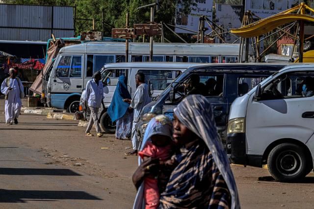 Sudanese walk at the public transportation station in the capital Khartoum on April 16, 2026. Of the nearly four million people -- around half Khartoum's pre-war population -- who fled during the conflict, more than 1.8 million have returned over the past year. Yet fewer than 80,000 people have come back to central Khartoum, according to the United Nations. (Photo by Khaled DESOUKI / AFP)