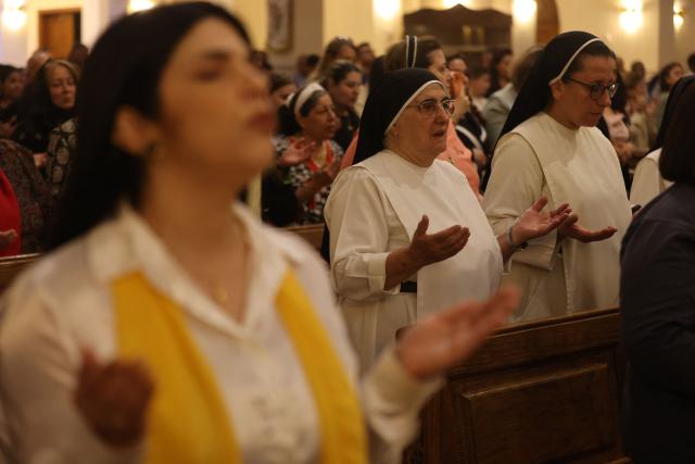 Nuns and Christian worshippers attend a service at the Coptic Orthodox Patriarchate Church during a mass for "World Peace", where all Christian denominations gathered to pray for an end to the war in the Middle East, in Baghdad on April 16, 2026.  (Photo by AHMAD AL-RUBAYE / AFP)