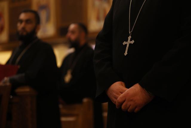 Clergy and Christian worshippers attend a service at the Coptic Orthodox Patriarchate Church during a mass for "World Peace", where all Christian denominations gathered to pray for an end to the war in the Middle East, in Baghdad on April 16, 2026.  (Photo by AHMAD AL-RUBAYE / AFP)