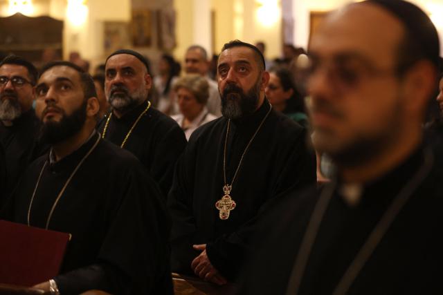 Clergy and Christian worshippers attend a service at the Coptic Orthodox Patriarchate Church during a mass for "World Peace", where all Christian denominations gathered to pray for an end to the war in the Middle East, in Baghdad on April 16, 2026.  (Photo by AHMAD AL-RUBAYE / AFP)