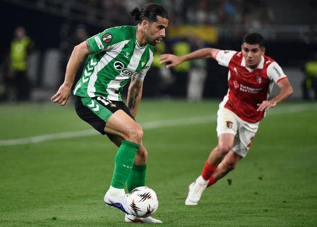 Real Betis' Swiss defender #12 Ricardo Rodriguez (L) and Sporting Braga's Spanish defender #02 Victor Gomez vie for the ball during the UEFA Europa League quarter final second leg football match between Real Betis and SC Braga at Benito Villamarin Stadium in Seville on April 16, 2026. (Photo by FRED TANNEAU / AFP)