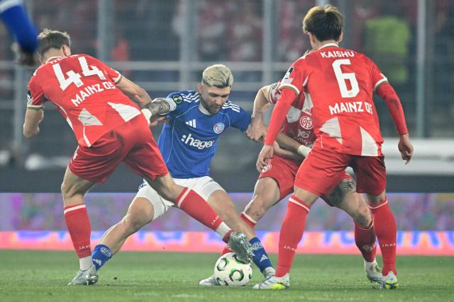 Strasbourg's Paraguayan midfielder #19 Julio Enciso (C) fights for the ball with Mainz' German forward #44 Nelson Weiper (L) during the UEFA Europa Conference League quarter-final second leg football match between RC Strasbourg Alsace and Mainz 05 at the Stade de La Meinau in Strasbourg, eastern France, on April 16, 2026. (Photo by SEBASTIEN BOZON / AFP)