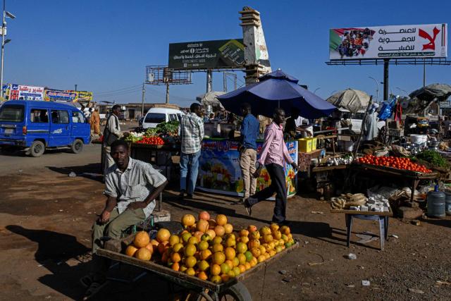 A vendor sits by a fresh produce stall at a local market in the capital Khartoum on April 16, 2026. Of the nearly four million people -- around half Khartoum's pre-war population -- who fled during the conflict, more than 1.8 million have returned over the past year. Yet fewer than 80,000 people have come back to central Khartoum, according to the United Nations. (Photo by Khaled DESOUKI / AFP)
