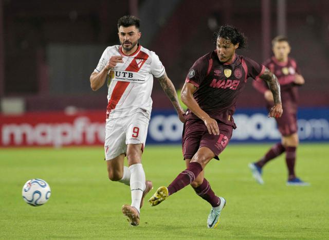 Always Ready's Argentine forward #9 Enrique Triverio and Lanus' Paraguayan defender #13 Jose Maria Canale fight for the ball during the Copa Libertadores group stage football match between Argentina's Lanus and Bolivia's Always Ready at the Ciudad de Lanus stadium in Lanus, Buenos Aires province, Argentina, on April 16, 2026. (Photo by JUAN MABROMATA / AFP)