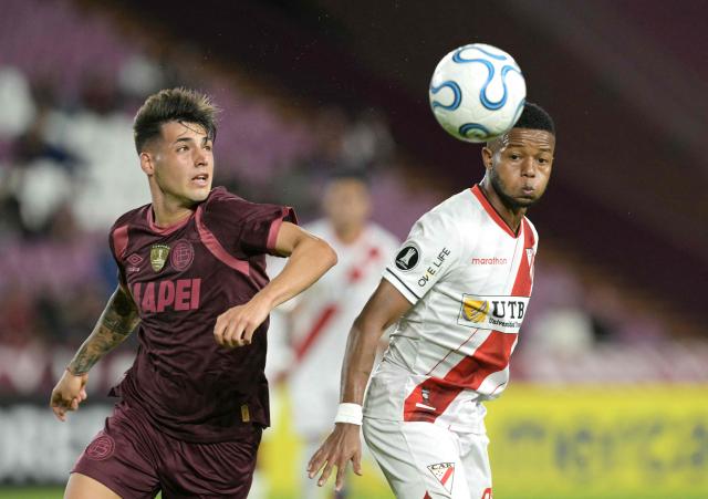 Lanus' forward #77 Lucas Besozzi and Always Ready's Colombian midfielder #27 Yhorman Hurtado fight for the ball during the Copa Libertadores group stage football match between Argentina's Lanus and Bolivia's Always Ready at the Ciudad de Lanus stadium in Lanus, Buenos Aires province, Argentina, on April 16, 2026. (Photo by JUAN MABROMATA / AFP)