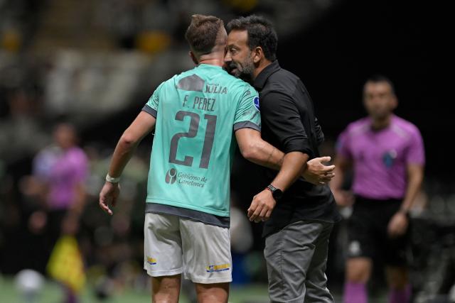 Juventud's midfielder #21 Facundo Perez celebrates with head coach Sergio Blanco after scoring his team's first goal during the Copa Sudamericana group stage football match between Brazil's Atletico Mineiro and Uruguay's Juventud at the Arena MRV stadium in Belo Horizonte, state of Minas Gerais, Brazil, on April 16, 2026. (Photo by DOUGLAS MAGNO / AFP)
