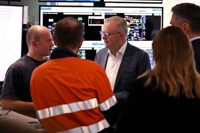 Australia's Prime Minister Anthony Albanese (C) speaks to Viva Energy staff in the control room of the Geelong Oil Refinery in Geelong on April 17, 2026. The visit comes a day after a fire ripped through the oil refinery but Australia's deputy Prime Minister Richard Marles said it would have a minimal impact on fuel supply. (Photo by William WEST / AFP)