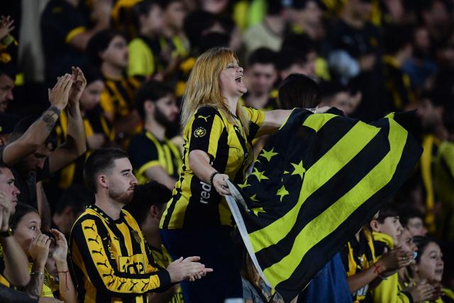 Fans of Penarol cheer for their team before the start of the Copa Libertadores group stage football match between Uruguay's Penarol and Argentina's Platense at the Campeon del Siglo stadium in Montevideo on April 16, 2026. (Photo by Dante FERNANDEZ / AFP)