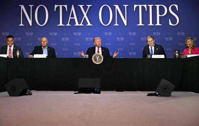 US President Donald Trump (C) speaks, flanked by US Secretary of Treasury Scott Bessent (2R) and Nevada Lieutenant Governor Stavros Anthony (2L), during a roundtable discussion on his "no tax on tips" policy at the AC Hotel Las Vegas Symphony Park in Las Vegas, Nevada, on April 16, 2026. (Photo by Jim WATSON / AFP)