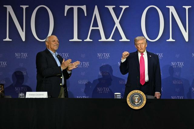US President Donald Trump (R) raises his fist, flanked by Nevada Lieutenant Governor Stavros Anthony (L), as he arrives for a roundtable discussion on his "no tax on tips" policy at the AC Hotel Las Vegas Symphony Park in Las Vegas, Nevada, on April 16, 2026. (Photo by Jim WATSON / AFP)
