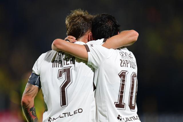 Platense's forward #07 Guido Mainero celebrates with teammate midfielder #10 Franco Zapiola after scoring his team's first goal during the Copa Libertadores group stage football match between Uruguay's Penarol and Argentina's Platense at the Campeon del Siglo stadium in Montevideo on April 16, 2026. (Photo by Dante FERNANDEZ / AFP)
