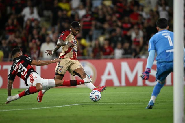 Independiente Medellin's forward #11 Yony Gonzalez shoots to score past Flamengo's defender #13 Danilo and Argentine goalkeeper #01 Agustin Rossi during the Copa Libertadores group stage football match between Brazil's Flamengo and Colombia's Independiente Medellin at the Maracana stadium in Rio de Janeiro, Brazil, on April 16, 2026. (Photo by MAURO PIMENTEL / AFP)