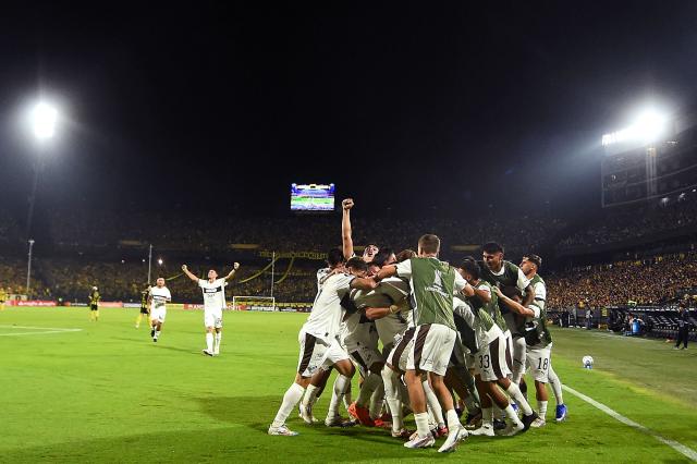 Platense's forward #07 Guido Mainero (unseen) celebrates with teammates after scoring his team's first goal during the Copa Libertadores group stage football match between Uruguay's Penarol and Argentina's Platense at the Campeon del Siglo stadium in Montevideo on April 16, 2026. (Photo by DANTE FERNANDEZ / AFP)