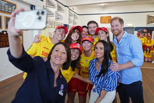 Britain's Prince Harry, Duke of Sussex, and his wife Meghan, the Duchess of Sussex, pose for a photo during a meeting with volunteer first responders from Bondi Surf Bathers' Life Saving Club at Bondi Beach in Sydney on April 17, 2026. (Photo by Jonathan Brady / POOL / AFP)