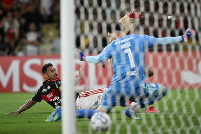 Independiente Medellin's forward #11 Yony Gonzalez (R, back) shoots to score past Flamengo's defender #13 Danilo and Argentine goalkeeper #01 Agustin Rossi during the Copa Libertadores group stage football match between Brazil's Flamengo and Colombia's Independiente Medellin at the Maracana stadium in Rio de Janeiro, Brazil, on April 16, 2026. (Photo by MAURO PIMENTEL / AFP)