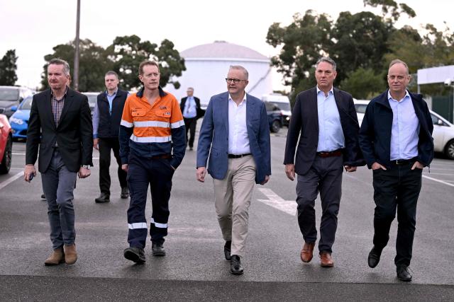 Australia's Prime Minister Anthony Albanese (C) walks with Minister for Climate Change and Energy Chris Bowen (L), Viva Energy's Bill Patterson (2/L), Deputy Prime Minister of Australia Richard Marles (2/R) and Viva Energy CEO Scott Wyatt (R) during a visit to the Geelong Oil Refinery in Geelong on April 17, 2026. The visit comes a day after a fire ripped through the oil refinery but Australia's deputy Prime Minister Richard Marles said it would have a minimal impact on fuel supply. (Photo by William WEST / AFP)
