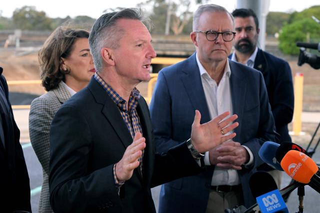 Minister for Climate Change and Energy Chris Bowen (C) speaks as Australia's Prime Minister Anthony Albanese (R) listens in a press conference during a visit to the Geelong Oil Refinery in Geelong on April 17, 2026. The visit comes a day after a fire ripped through the oil refinery but Australia's deputy Prime Minister Richard Marles said it would have a minimal impact on fuel supply. (Photo by William WEST / AFP)
