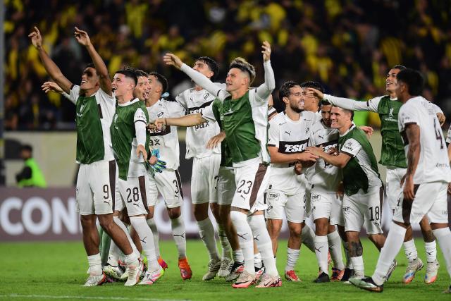 Platense players celebrate after winning the Copa Libertadores group stage football match between Uruguay's Penarol and Argentina's Platense at the Campeon del Siglo stadium in Montevideo on April 16, 2026. (Photo by Dante FERNANDEZ / AFP)