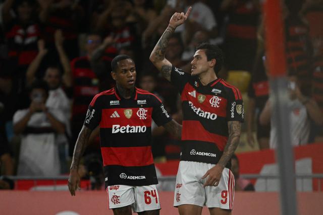 Flamengo's forward #09 Pedro celebrates with teammate midfielder #64 Wallace Yan after scoring his team's fourth goal during the Copa Libertadores group stage football match between Brazil's Flamengo and Colombia's Independiente Medellin at the Maracana stadium in Rio de Janeiro, Brazil, on April 16, 2026. (Photo by MAURO PIMENTEL / AFP)