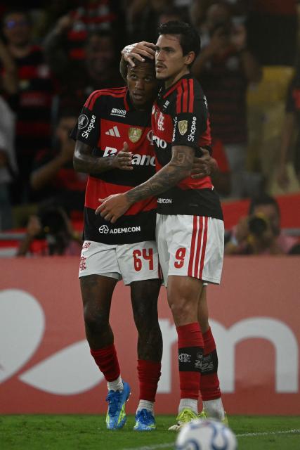Flamengo's forward #09 Pedro celebrates with teammate midfielder #64 Wallace Yan after scoring his team's fourth goal during the Copa Libertadores group stage football match between Brazil's Flamengo and Colombia's Independiente Medellin at the Maracana stadium in Rio de Janeiro, Brazil, on April 16, 2026. (Photo by MAURO PIMENTEL / AFP)