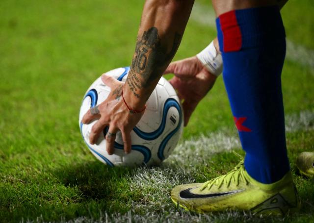 A tattoo depicting Argentine football player Lionel Messi is pictured on the arm of San Lorenzo's forward #11 Matias Reali as he prepares to take a corner kick during the Copa Sudamericana group stage football match between Argentina's San Lorenzo and Ecuador's Deportivo Cuenca at Pedro Bidegain stadium in Buenos Aires on April 16, 2026. (Photo by Luis ROBAYO / AFP)