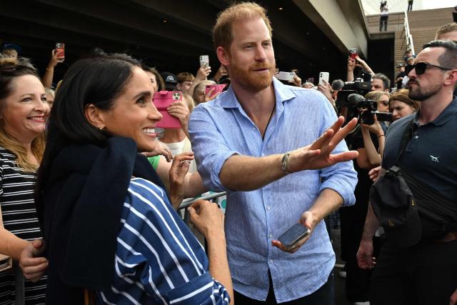 Britain’s Prince Harry, Duke of Sussex, and his wife Meghan, Duchess of Sussex, meet with members of the public beneath the steps of Australia’s iconic Sydney Opera House on April 17, 2026. (Photo by Saeed KHAN / AFP)