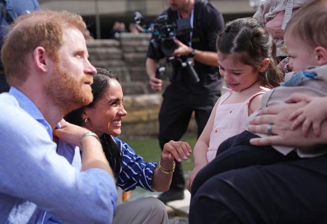 Britain's Prince Harry (L), Duke of Sussex, and his wife Meghan, the Duchess of Sussex, meet veteran Joel Vanderzwan and his wife Alexandra, daughter Charlotte and twin sons Harrison and William, before taking part in a sailing event with members of Invictus Australia in Sydney Harbour on April 17, 2026. (Photo by Jonathan Brady / POOL / AFP)