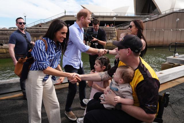 Britain's Prince Harry (top C), Duke of Sussex, and his wife Meghan (L), the Duchess of Sussex, meet veteran Joel Vanderzwan (R) and his wife Alexandra, daughter Charlotte and twin sons Harrison and William, before taking part in a sailing event with members of Invictus Australia in Sydney Harbour on April 17, 2026. (Photo by Jonathan Brady / POOL / AFP)