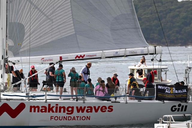 Britain's Prince Harry (C), Duke of Sussex, and his wife Meghan, the Duchess of Sussex, take part in a sailing event with members of Invictus Australia in Sydney Harbour on April 17, 2026. (Photo by Saeed KHAN / AFP)