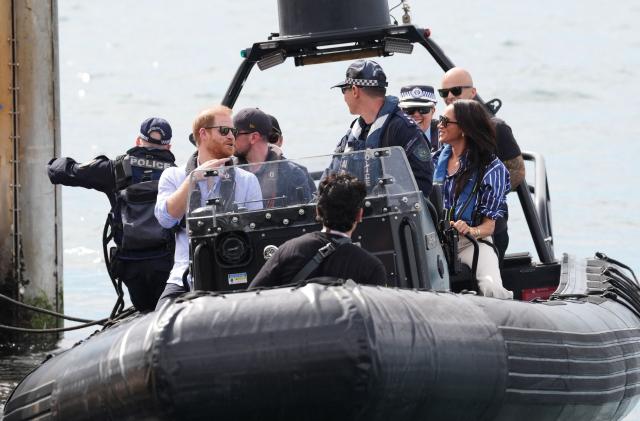 Britain's Prince Harry (L), Duke of Sussex, and his wife Meghan (R), the Duchess of Sussex, ride on a police boat to a yacht before taking part in a sailing event with members of Invictus Australia in Sydney Harbour on April 17, 2026. (Photo by Jonathan Brady / POOL / AFP)