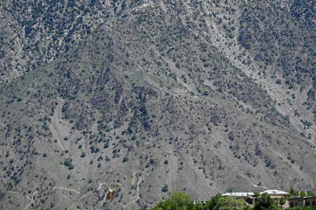 This photograph taken on April 13, 2026 shows a general view of the Durand Line border between Pakistan and Afghanistan in the Barikot village of Naray district, Kunar province. There are no children in the Afghan border village of Barikot, where the school has been smashed by shells and the playground sits deserted after weeks of war with Pakistan. More than 94,000 Afghans have been displaced by the war, OCHA figures show, more than a quarter of them in Kunar province. (Photo by Wakil KOHSAR / AFP)