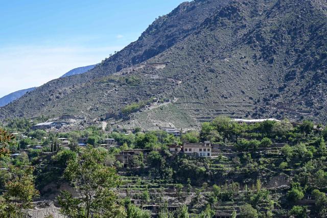 This photograph taken on April 13, 2026 shows a general view of the Durand Line border between Pakistan and Afghanistan in the Barikot village of Naray district, Kunar province. There are no children in the Afghan border village of Barikot, where the school has been smashed by shells and the playground sits deserted after weeks of war with Pakistan. More than 94,000 Afghans have been displaced by the war, OCHA figures show, more than a quarter of them in Kunar province. (Photo by Wakil KOHSAR / AFP)
