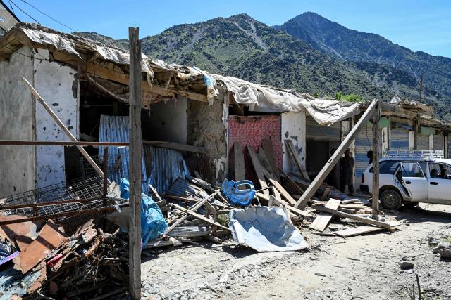 This photograph taken on April 13, 2026 shows damaged shops after they were hit by a Pakistani mortar shell during a conflict between Taliban security personnel and Pakistani forces at a market near the Durand Line border between Pakistan and Afghanistan in the Barikot village of Naray district, Kunar province. There are no children in the Afghan border village of Barikot, where the school has been smashed by shells and the playground sits deserted after weeks of war with Pakistan. More than 94,000 Afghans have been displaced by the war, OCHA figures show, more than a quarter of them in Kunar province. (Photo by Wakil KOHSAR / AFP)