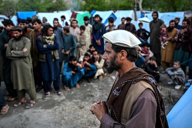 This photograph taken on April 12, 2026 shows internally displaced Afghan primary school principal Mohammad Amin Shakir speaking during an interview with AFP as he stands near temporary tents along a river amid the ongoing conflict between Pakistani forces and Taliban security personnel in the Marawara district of Kunar province. There are no children in the Afghan border village of Barikot, where the school has been smashed by shells and the playground sits deserted after weeks of war with Pakistan. More than 94,000 Afghans have been displaced by the war, OCHA figures show, more than a quarter of them in Kunar province. (Photo by Wakil KOHSAR / AFP)